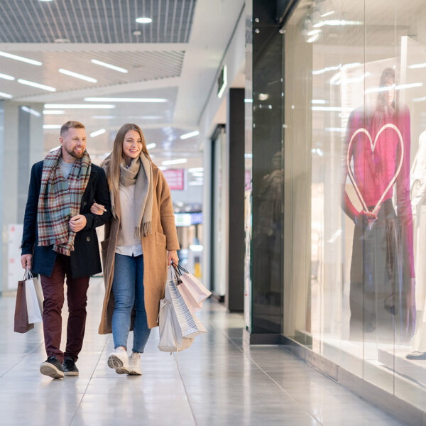 un couple passe devant une vitre qui adapte son message avec un coeur